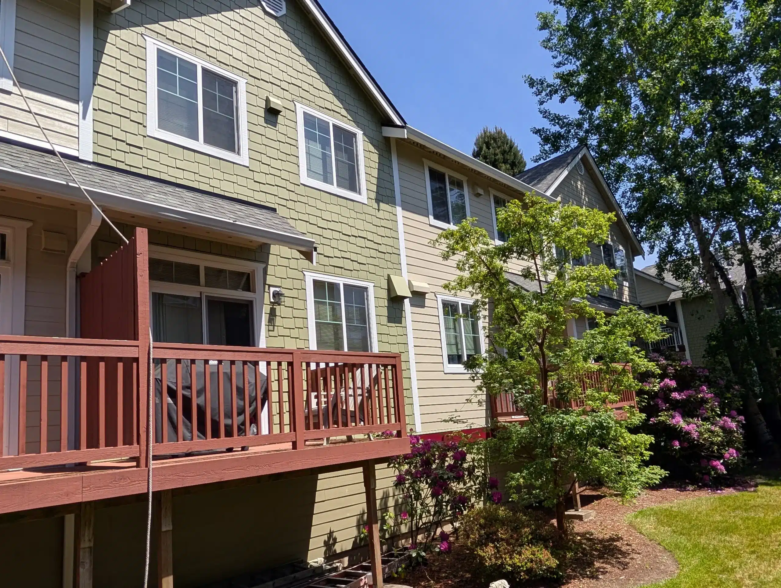 Commercial Siding Painting and Exterior Renovation Commercial residential building with freshly painted siding, white trim, landscaped surroundings, and restored exterior appearance.